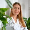 A jovem jornalista húngara, Lili Rutai, sentada tendo uma parede branca como fundo. Crédito: Lili Rutai 