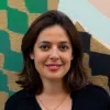 Retrato da politóloga Susana Coroado, sobre uma parede com desenhos.