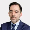 Retrato do comentador desportivo Carlos Freitas sobre um fundo cinza claro.