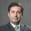 Retrato de Luís Rebelo, especialista em transição energética, num fundo cinzento escuro.