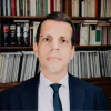 Imagem do advogado João Oliveira Geraldes, com uma estante de livros ao fundo.
