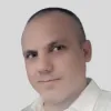 Retrato a cores de um homem, vestido com uma camisa branca. Fundo claro.