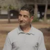 Retrato a cores de um homem, vestido com um polo cinzento. 