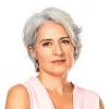 Retrato a cores de uma mulher de cabelo cinza, vestida com uma blusa rosa.